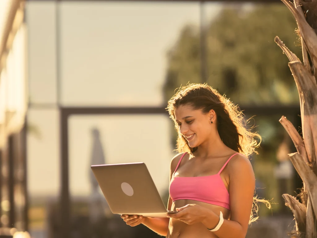 Creadora de contenido chilena profesional trabajando desde casa con laptop y teléfono, representando el éxito en OnlyFans en Chile durante 2026