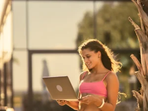 Creadora de contenido chilena profesional trabajando desde casa con laptop y teléfono, representando el éxito en OnlyFans en Chile durante 2026